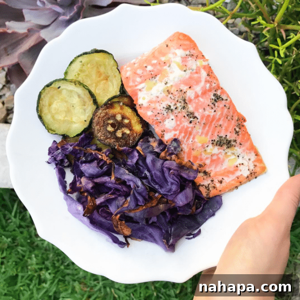 A plate with salmon, cabbage, and zucchini on it