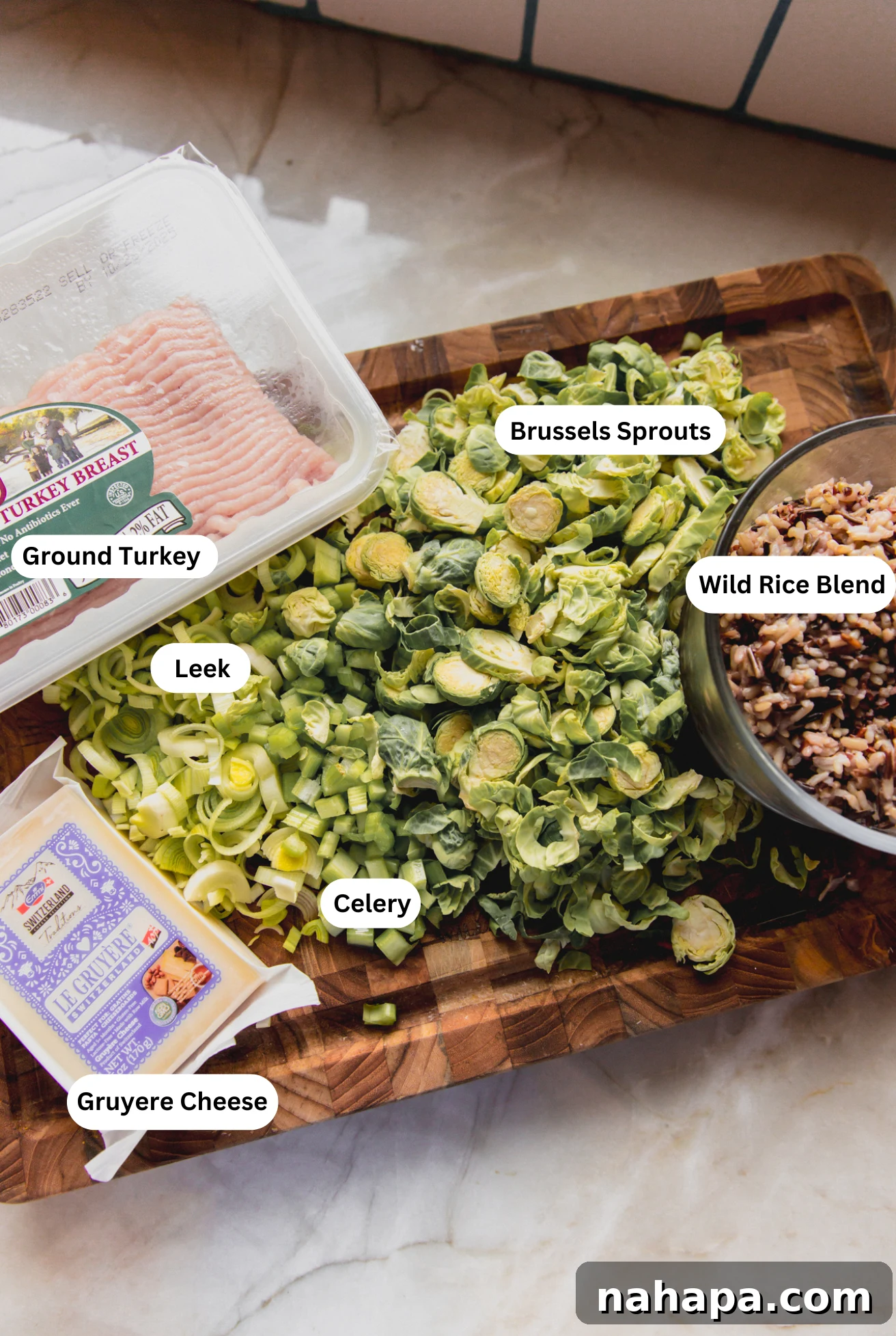 Close-up photo of raw wild rice pumpkin ingredients laid out on a cutting board, including pumpkin, ground turkey, and various vegetables.