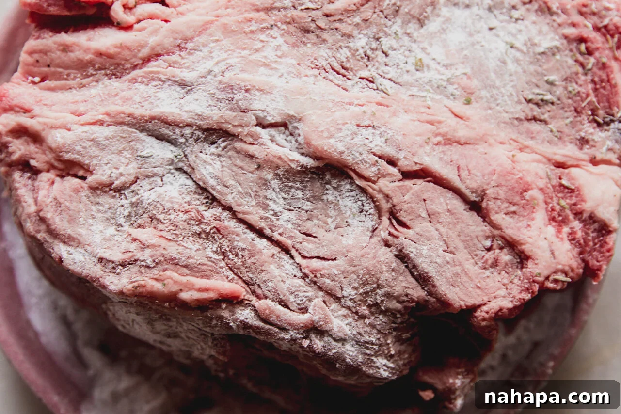 The chuck roast covered in a seasoned arrowroot starch mixture, ready for searing.