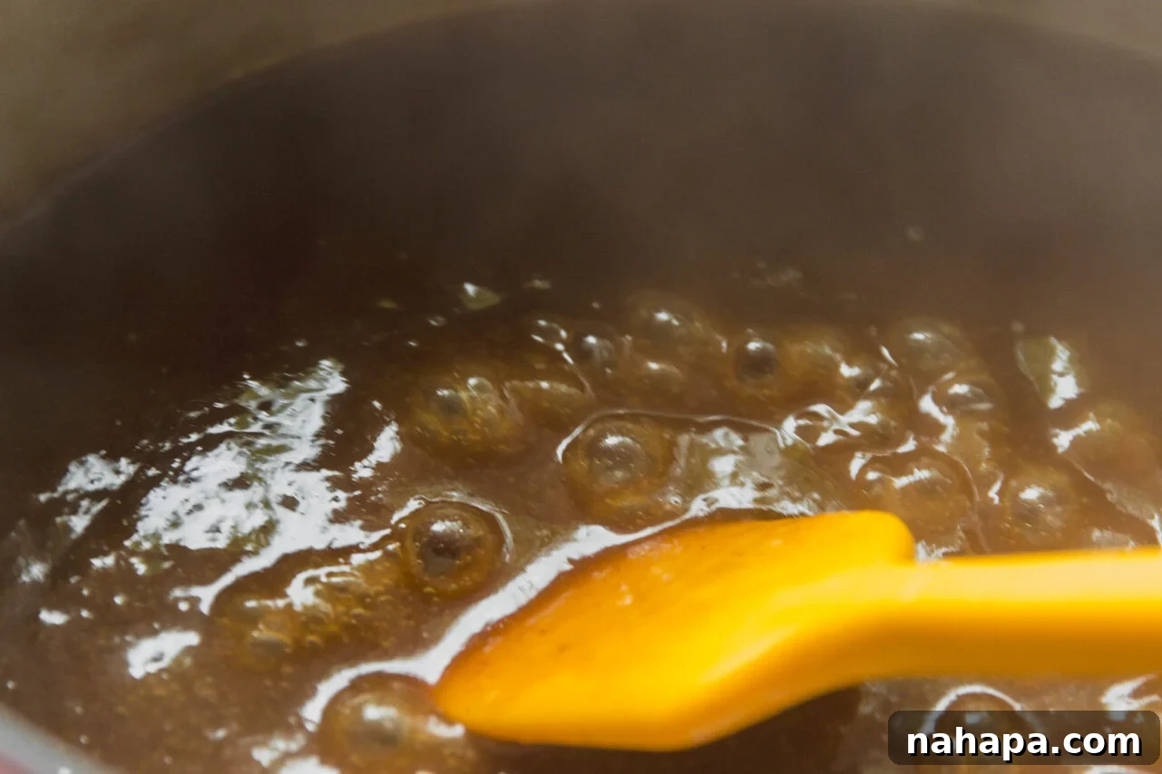 The gravy thickening on the stovetop, simmering gently.