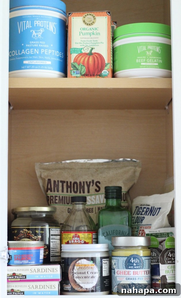 A shot of a pantry containing Cassava flour, apple cider vinegar, olive oil and many other products.