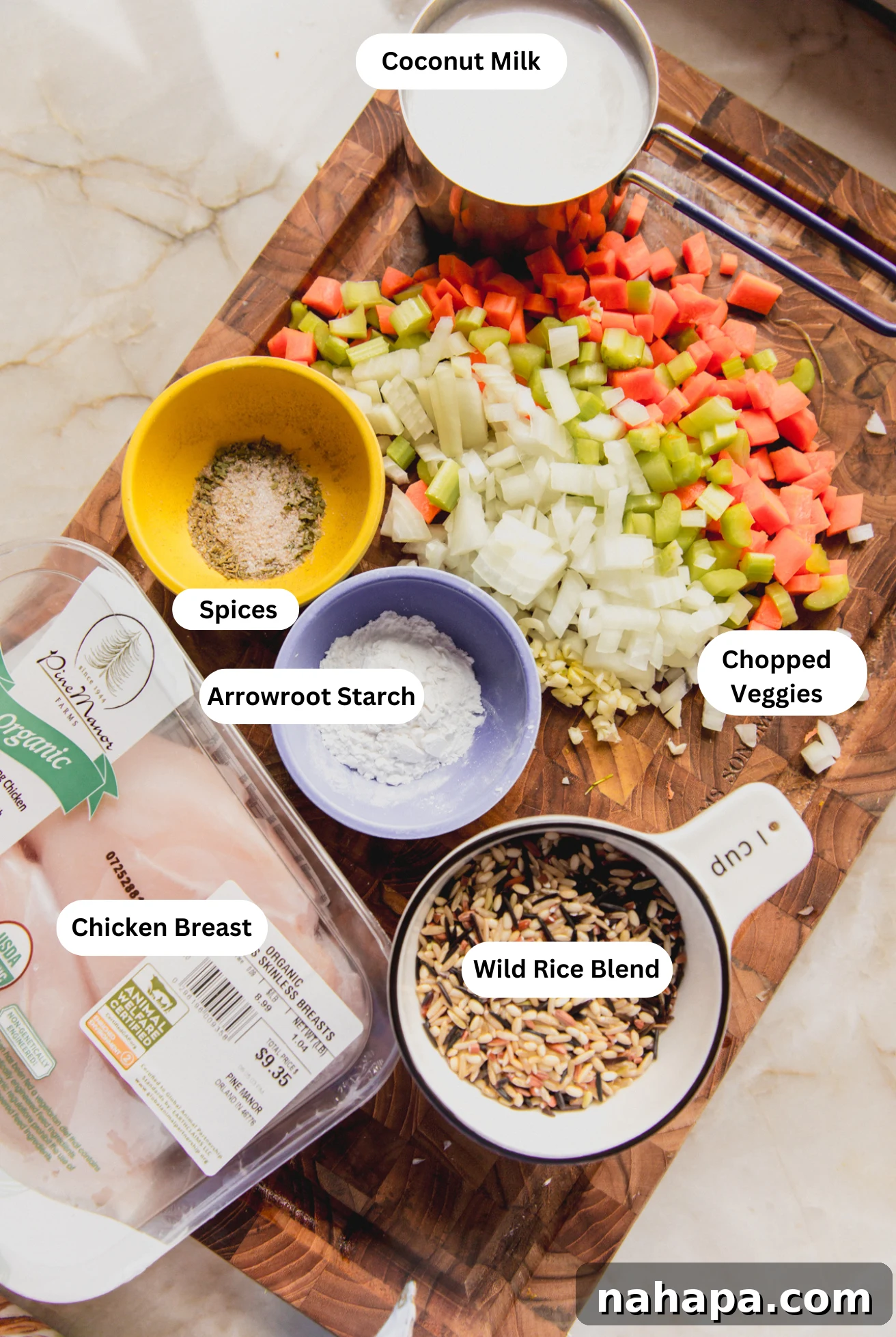 Velvety Gluten-Free Chicken and Wild Rice Soup 3 A flat lay of all the fresh ingredients for creamy chicken and wild rice soup, including chicken breast, various vegetables, and spices.