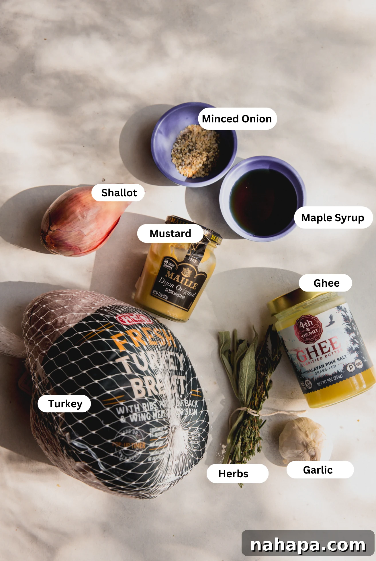 Tender Maple Dijon Slow Cooker Turkey Breast 3 All the ingredients needed to make slow cooker maple dijon turkey breast, including herbs, oranges, shallots, garlic, ghee, maple syrup, and dijon mustard, arranged on a kitchen counter.