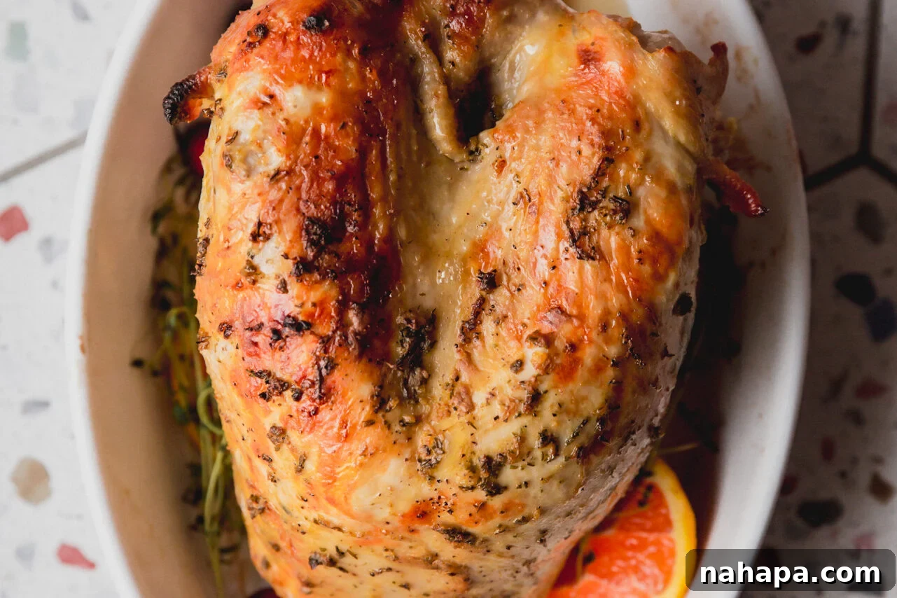 Tender Maple Dijon Slow Cooker Turkey Breast 7 Sliced slow cooker turkey breast served in a white ceramic bowl, surrounded by green vegetables and orange slices, ready to be enjoyed.