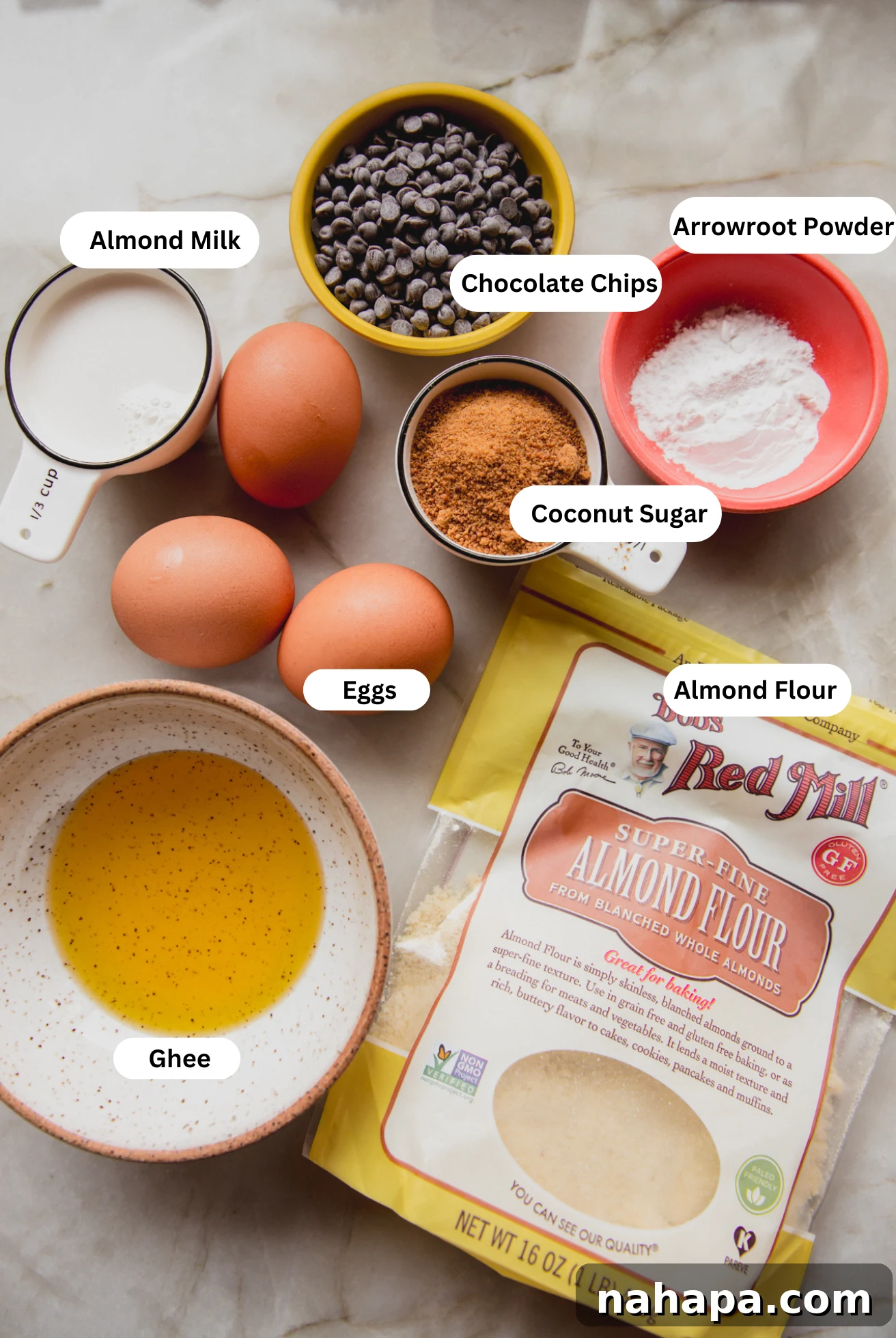 Decadent Gluten-Free Chocolate Chip Cookie Pie 3 All the essential ingredients neatly laid out on a kitchen counter: almond flour, coconut sugar, ghee, eggs, vanilla extract, and chocolate chips, ready for baking this delicious cookie pie.