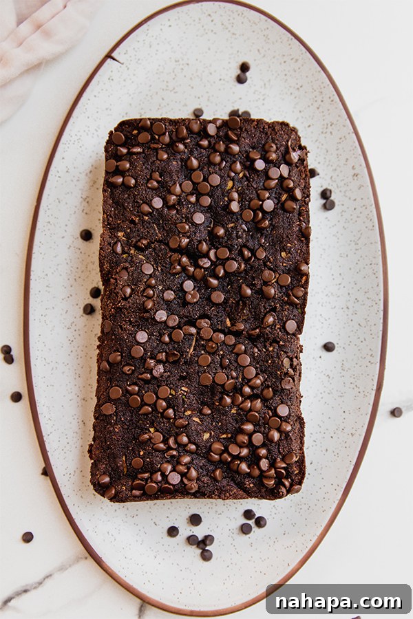 A perfectly baked loaf of chocolate zucchini bread on a cooling rack.