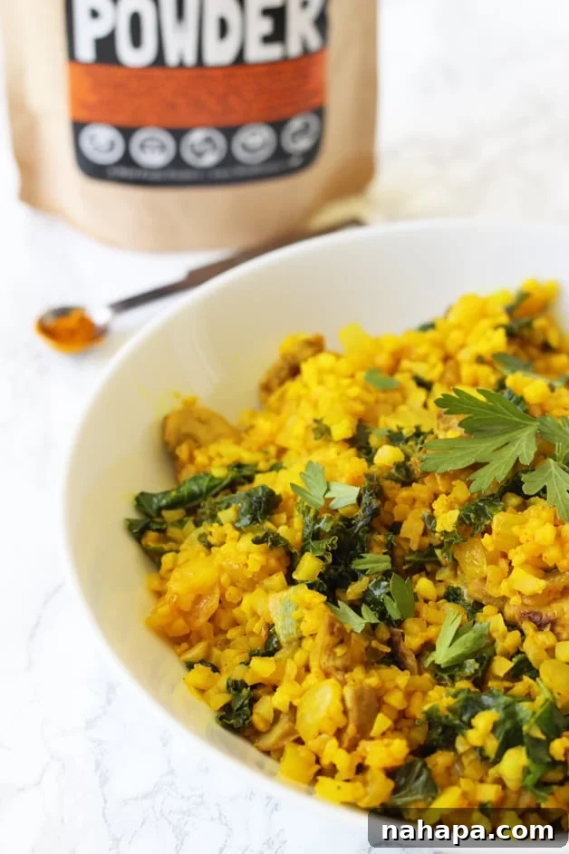 Close-up of Turmeric Cauliflower Risotto (AIP, Paleo, Whole30) with a spoon
