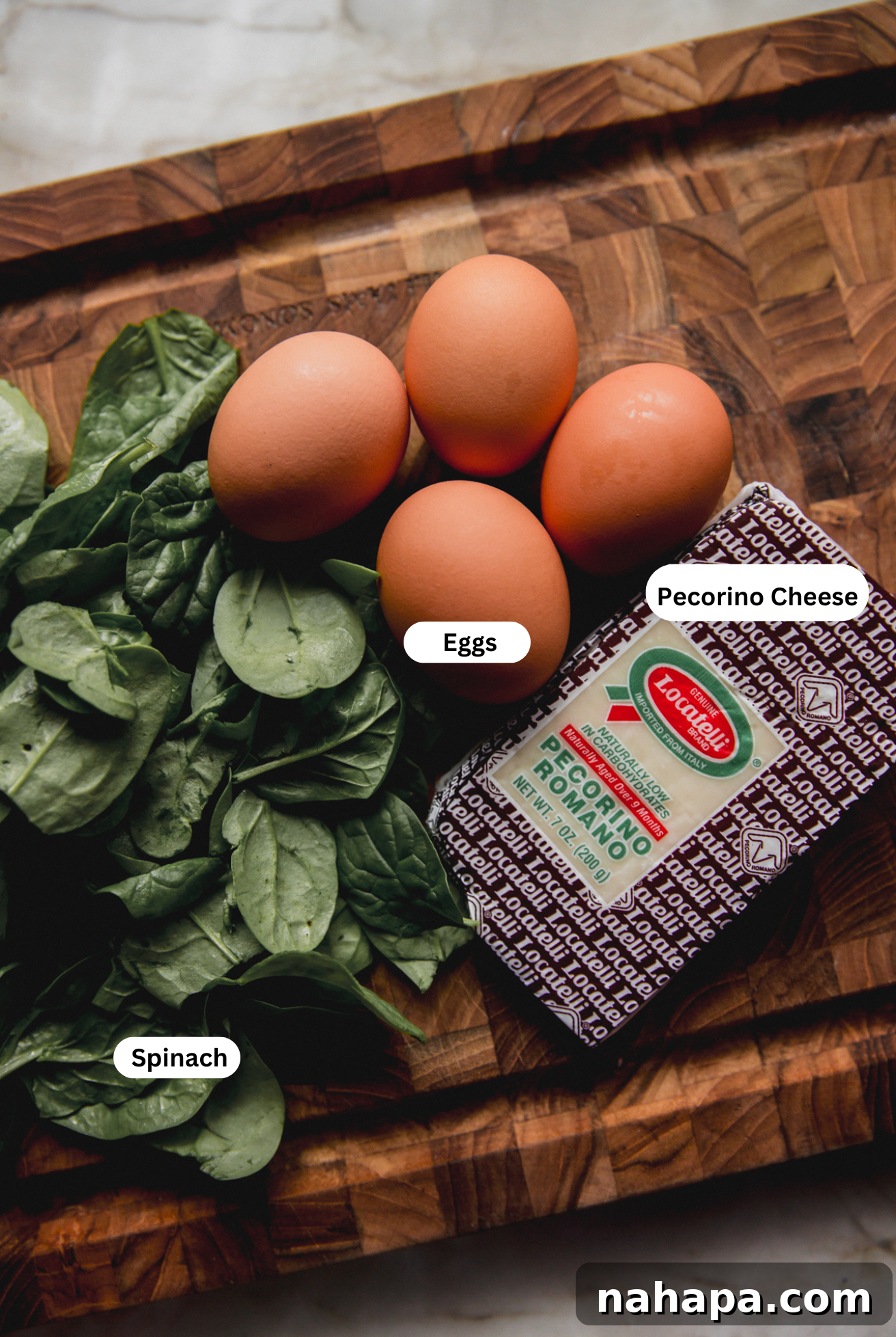 Key ingredients for Stracciatella soup including fresh eggs, vibrant spinach, and grated Pecorino cheese, beautifully arranged on a rustic wooden cutting board.