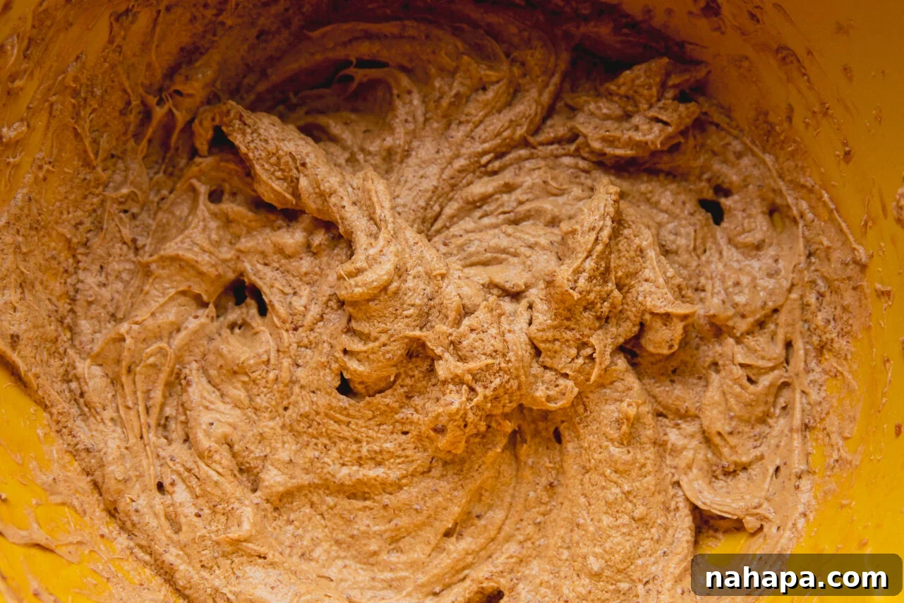 A yellow bowl filled with perfectly mixed chocolate cookie dough, ready for chilling.
