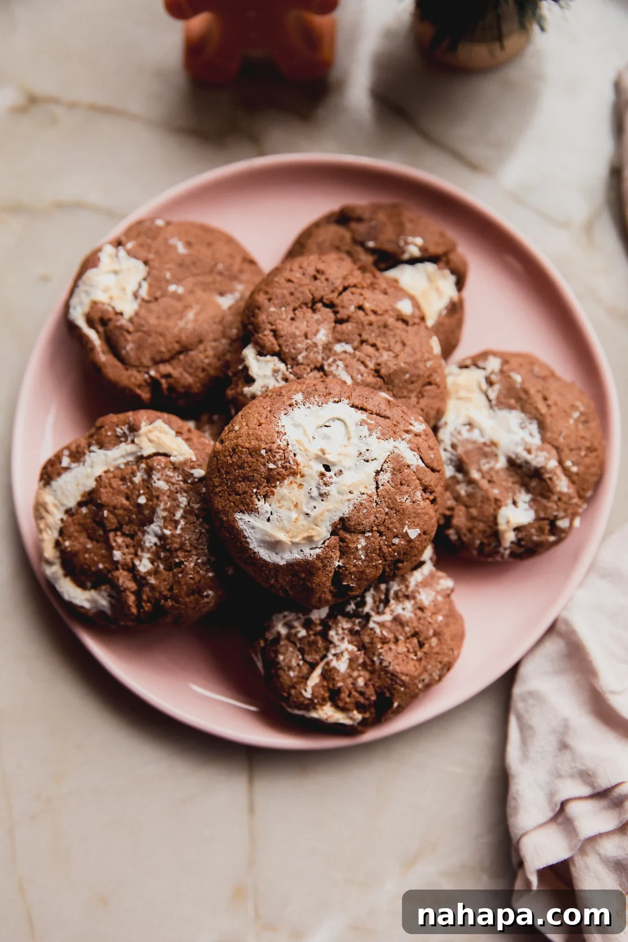 A vibrant pink plate generously stacked with perfectly baked gluten-free chocolate marshmallow cookies, each one a testament to their deliciousness.