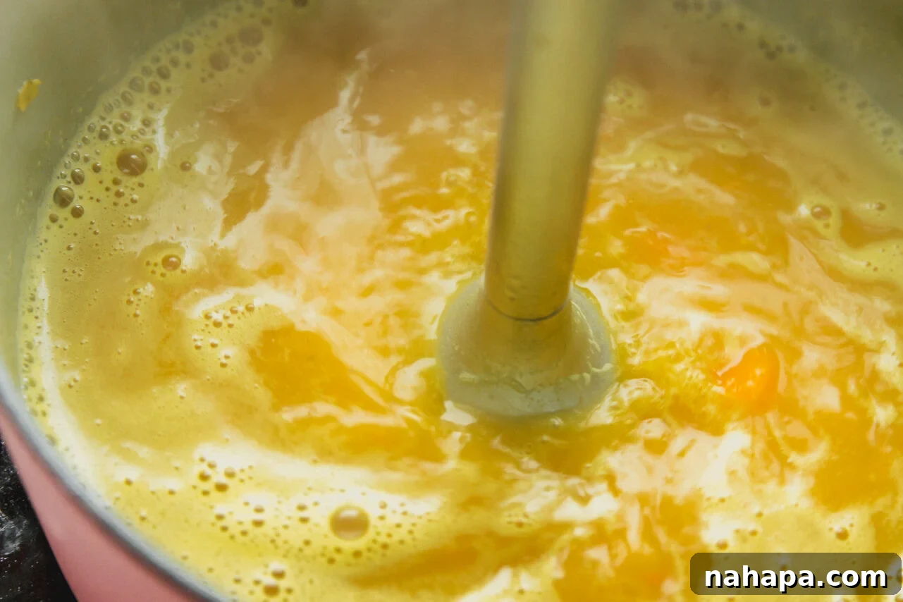 The soup base simmering in a pot, ready for blending, with cooked pasta in a separate bowl.