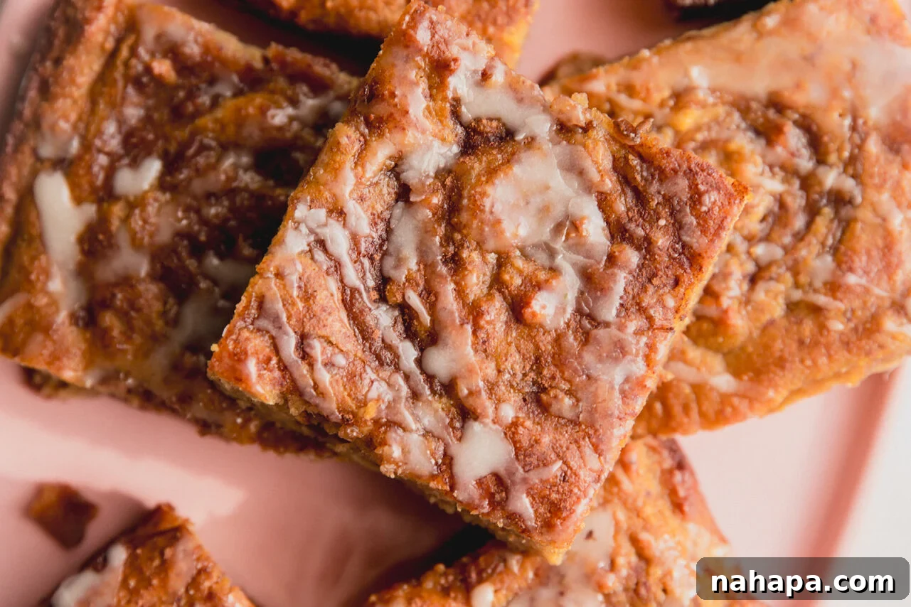Cut pieces of cinnamon roll cake on a pink plate.