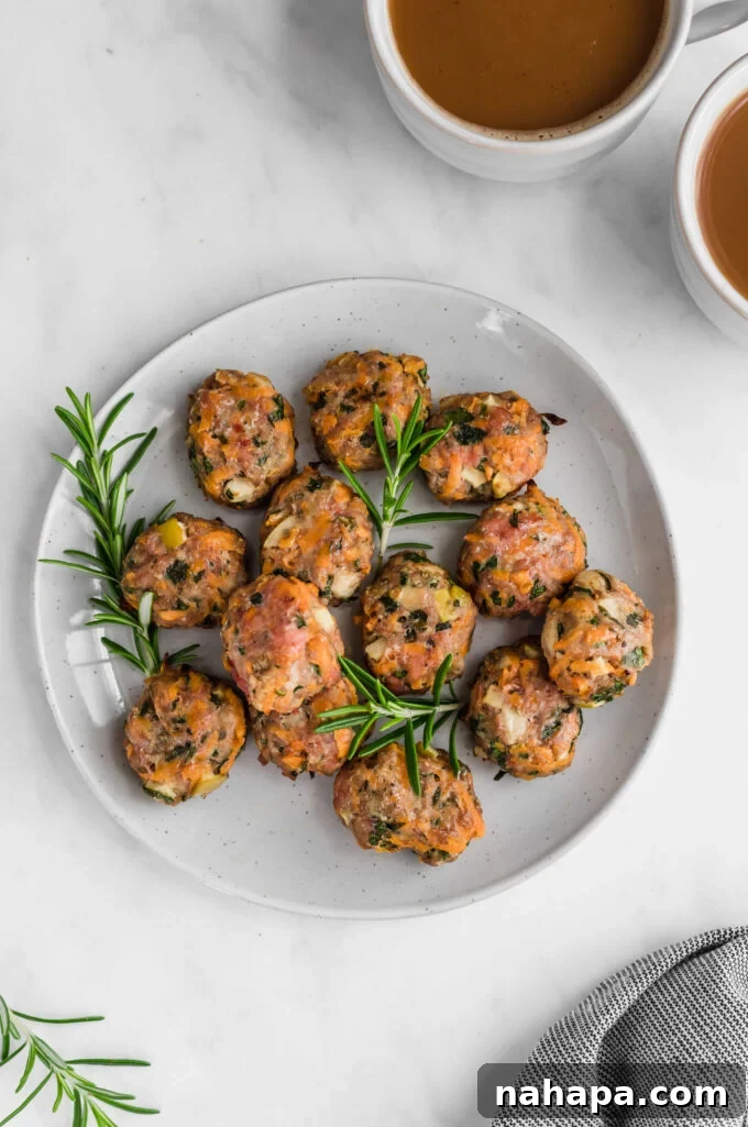 Golden-brown breakfast sausage chicken poppers artfully arranged on a rustic plate, garnished with fresh herbs and a hint of apple