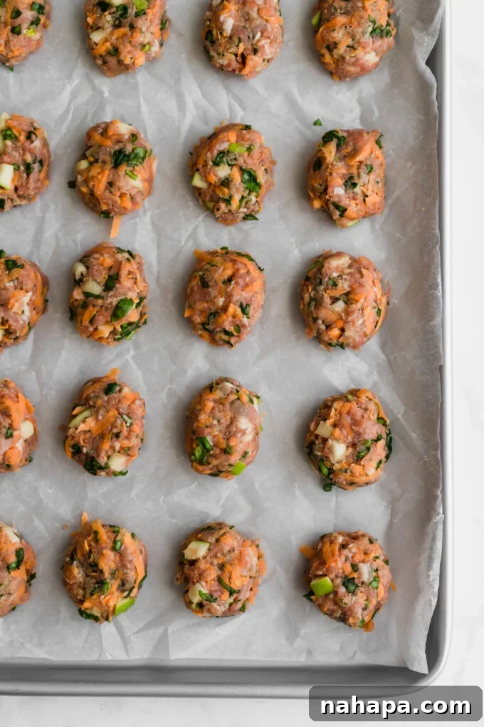 Breakfast sausage chicken poppers being rolled by hand