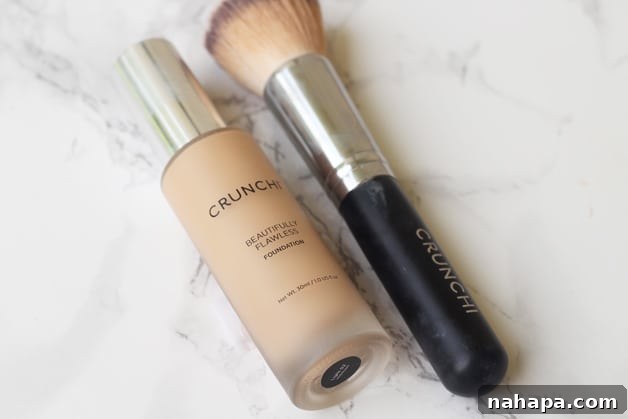 A bottle of foundation and a brush lying next to each other on a counter.