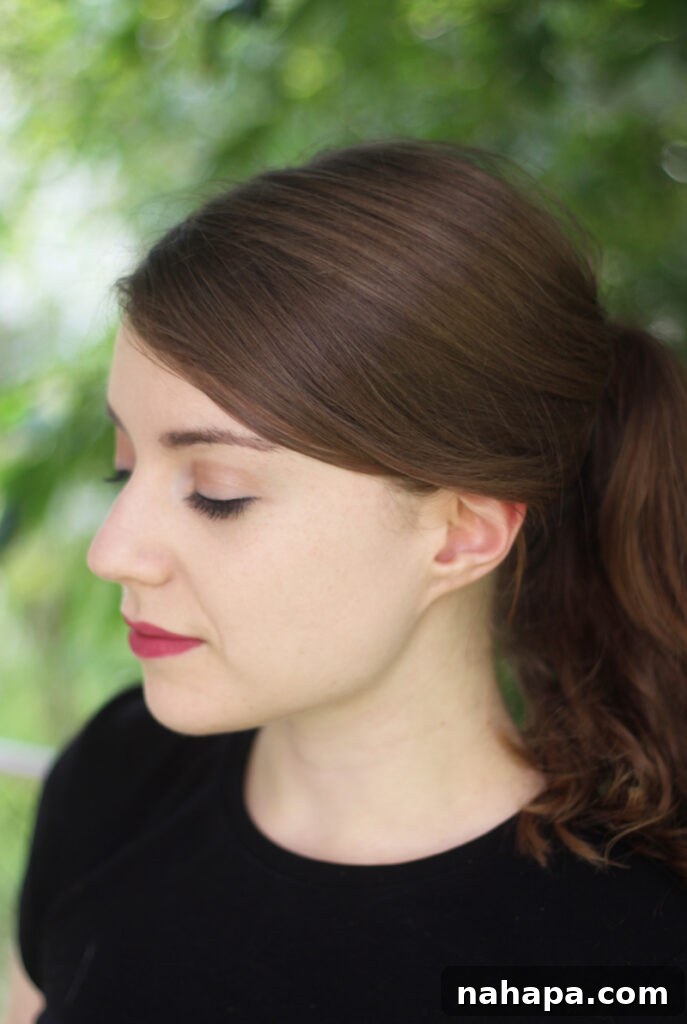 A photo of Michelle against a green background looking down.
