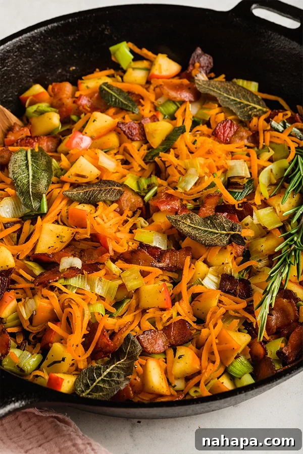 Sweet and Savory Whole30 Paleo AIP Carrot Apple Bacon Hash 4 Up close image of cooked breakfast hash in cast iron skillet, with steam rising