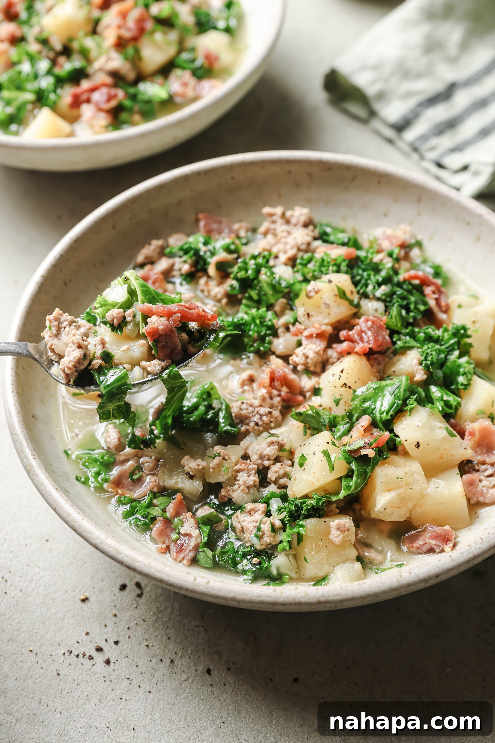 A perfectly portioned bowl of Zuppa Toscana, ready to be enjoyed, with garnishes.