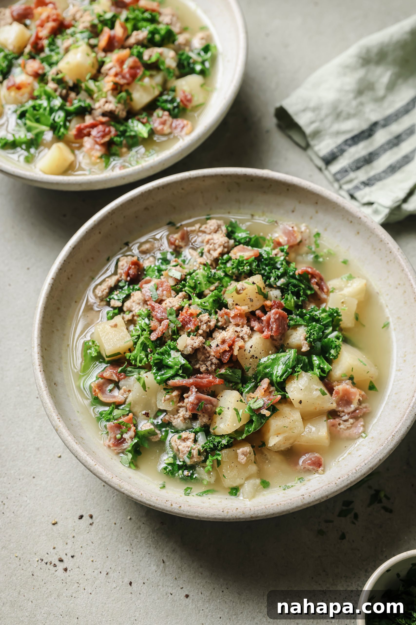 Two bowls of Instant Pot Zuppa Toscana soup, beautifully plated.