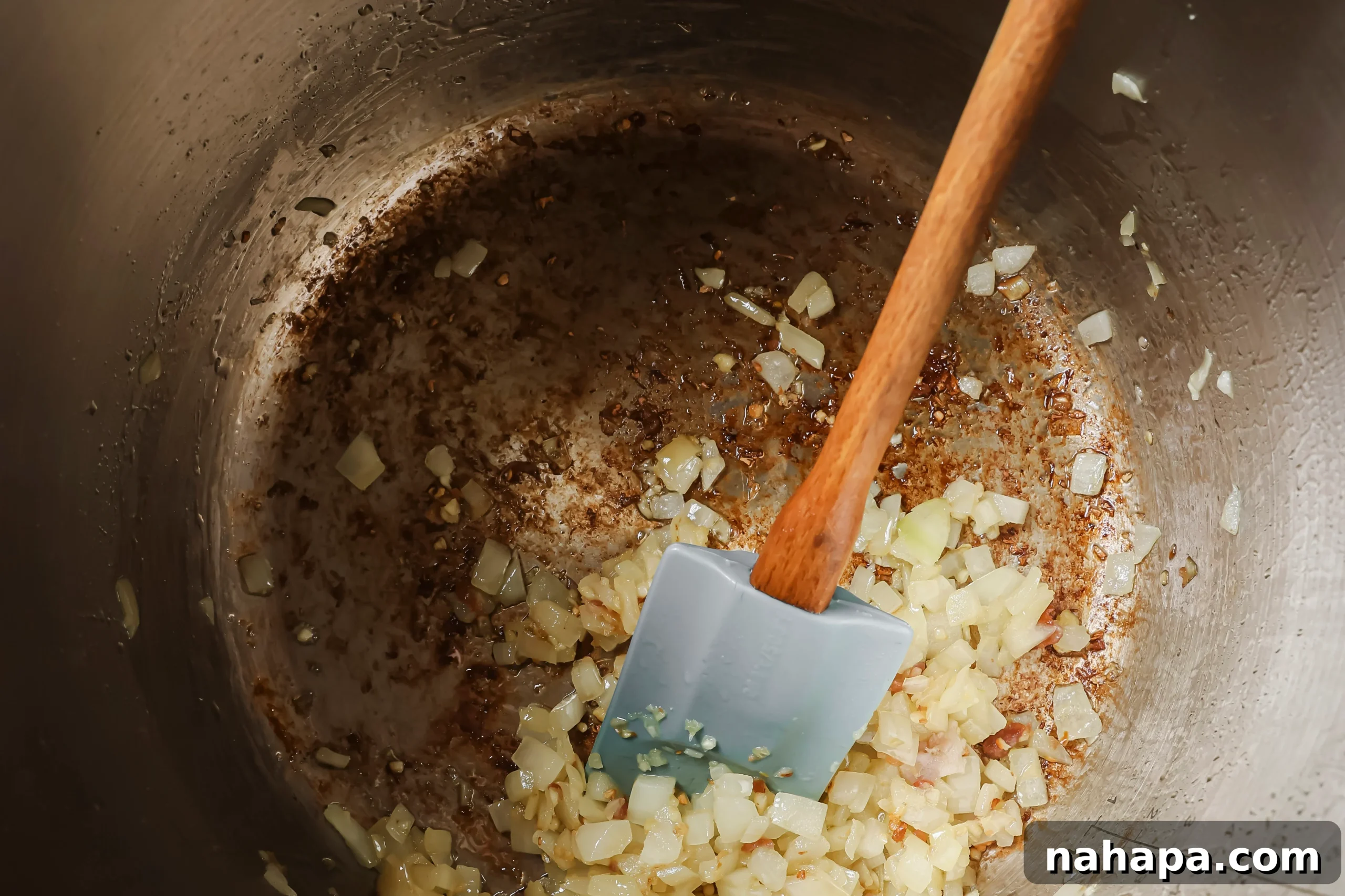 Diced onion and minced garlic sautéing in bacon fat in the Instant Pot.