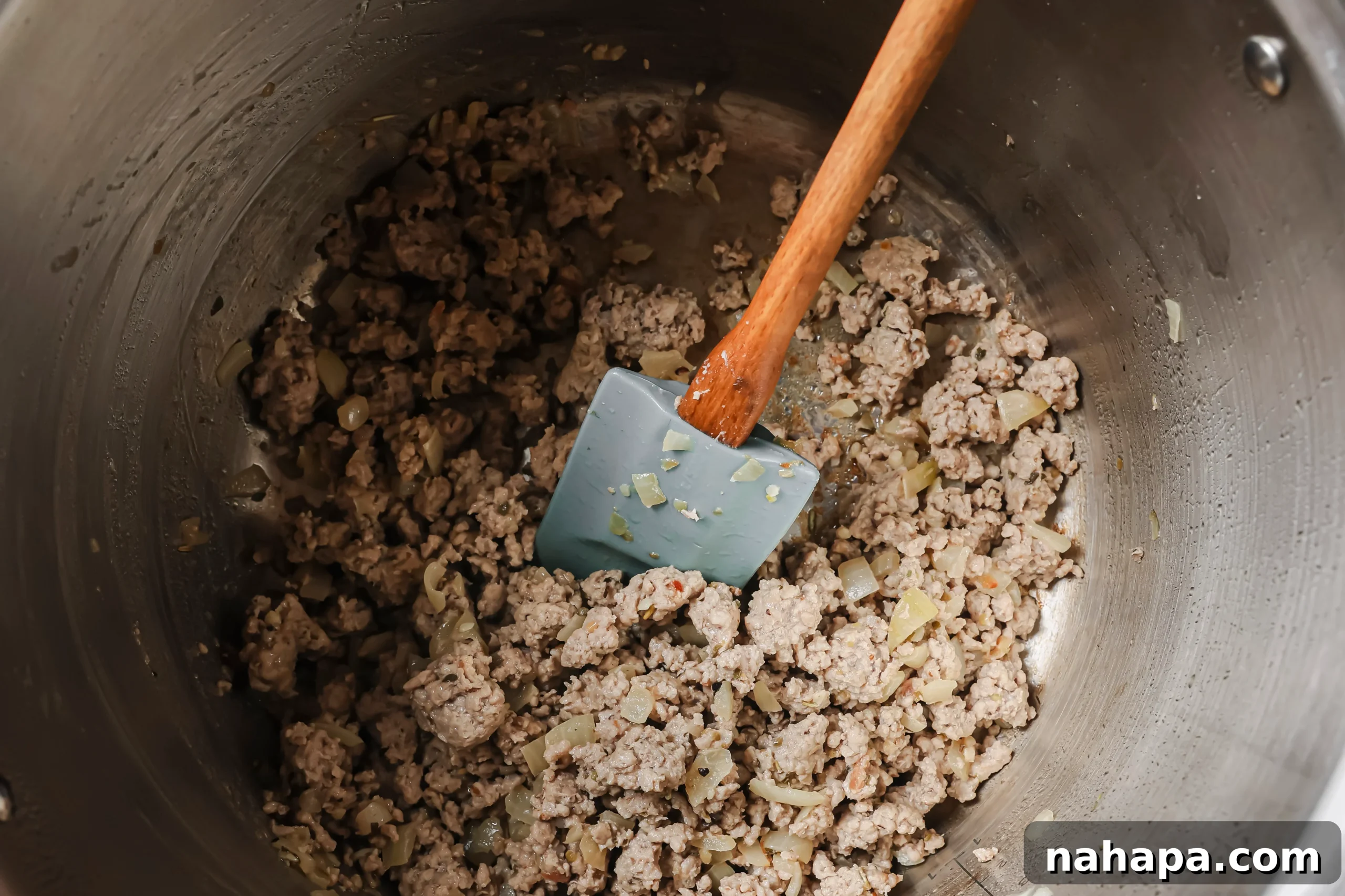Ground Italian sausage browning in the Instant Pot with sautéed onions and garlic.
