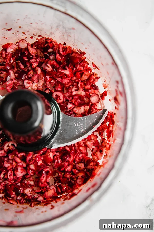 Fresh cranberries being processed in a food processor for turkey poppers
