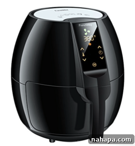 Paleo Holiday Gift Guide 4 A modern black air fryer stands ready on a kitchen counter, its sleek design suggesting ease of use and efficient cooking. The basket handle is visible, hinting at the crispy results within.