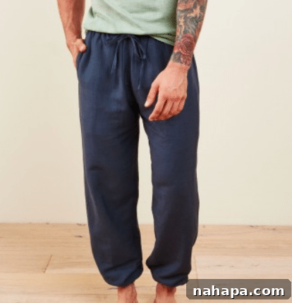 Paleo Holiday Gift Guide 7 A man sports a casual yet stylish look in navy blue joggers paired with a relaxed green shirt. The outfit conveys effortless comfort and modern ease.