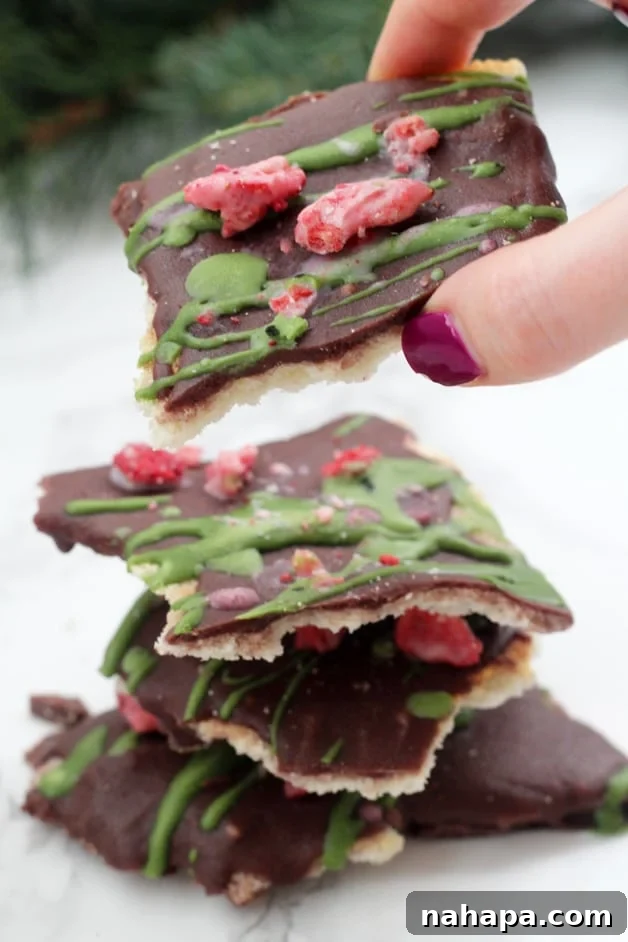 Paleo AIP Holiday Toffee Bars 2 A stack of paleo Christmas Crack with a hand taking the top piece off.