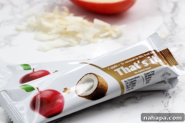 Two coconut apple That's Its bars on a counter.