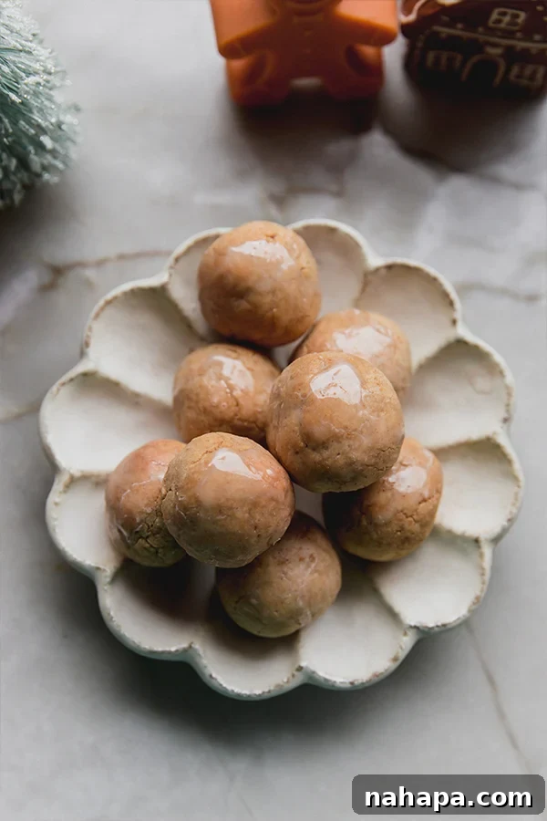 A serving plate beautifully arranged with freshly baked gingerbread donut holes, ready to be enjoyed.