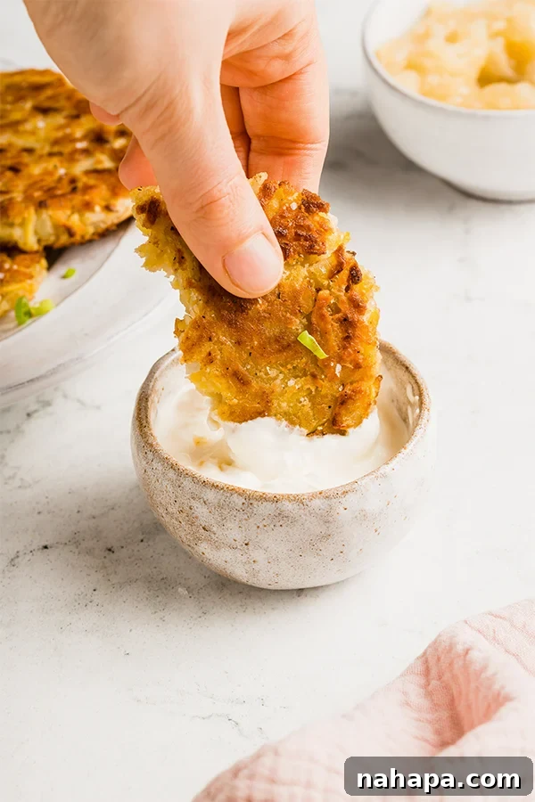 Stack of Sweet Potato Latkes with a bowl of applesauce