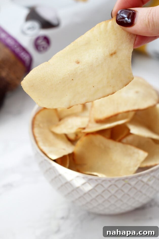 A crisp, close-up image of a white bowl overflowing with golden-brown cassava chips, perfectly showcasing their inviting texture.