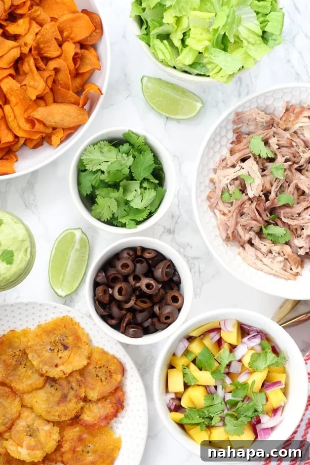 The Ultimate Super Bowl Paleo Nacho Bar Whole30 and AIP 2 Various healthy ingredients laid out for a Paleo Nacho Bar, including plantain chips, slow cooker carnitas, black olives, fresh salsa, cilantro, and lime wedges.