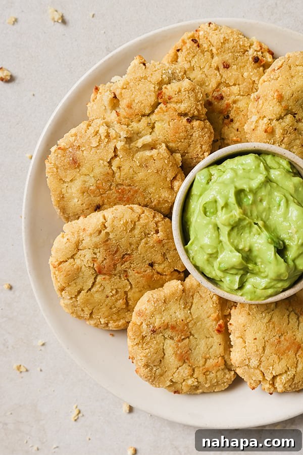 A bowl of cauliflower veggie nuggets served with fresh guacamole for dipping.