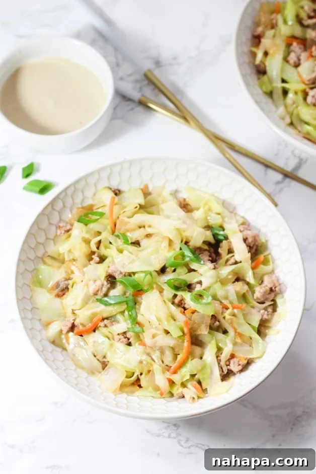 A white bowl filled with egg roll in a bowl and chop sticks nearby.