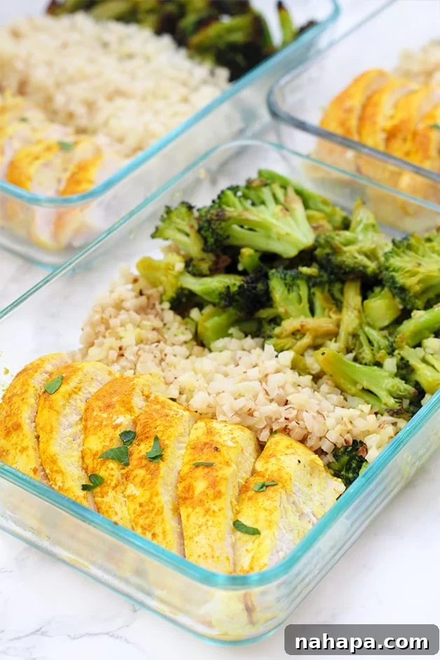 Wellness Turmeric Chicken Meal Prep 4 A glass meal prep container filled with turmeric chicken, cauliflower rice, and roasted broccoli.