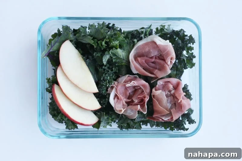 A fresh AIP-compliant salad with Italian kale, sliced apples, and prosciutto