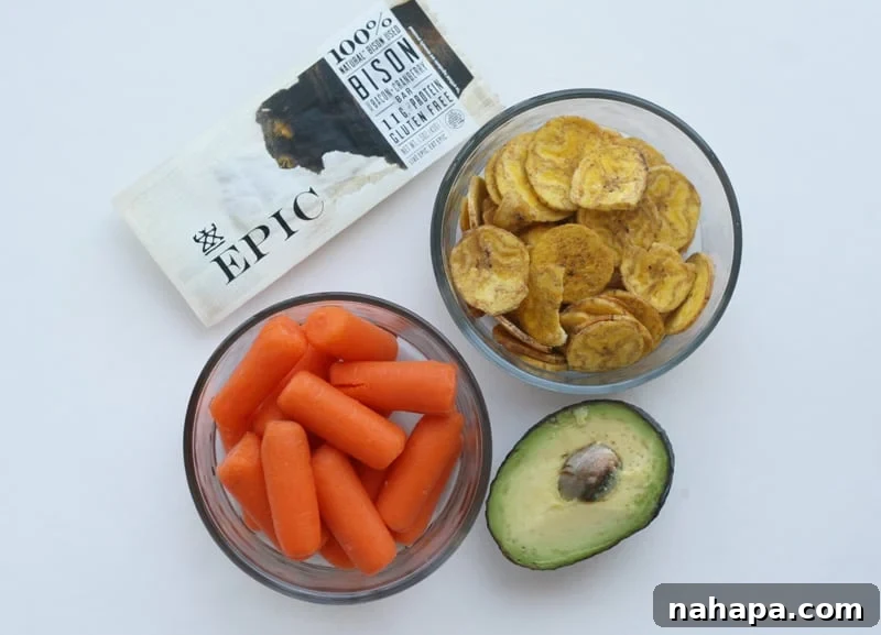 An easy AIP no-cook lunch featuring a bison Epic Bar, avocado, baby carrots, and plantain chips