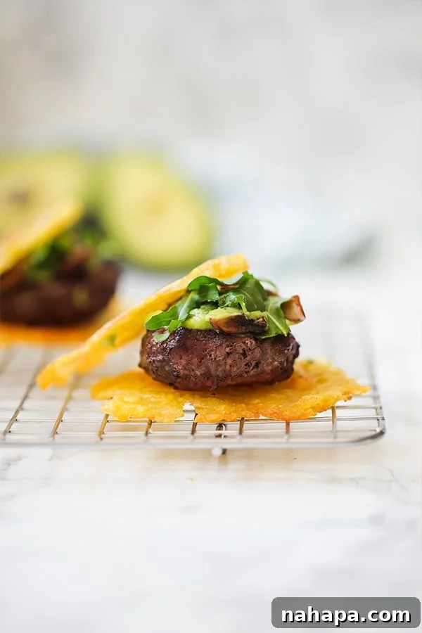 A tostone slider topped with avocado and greens, resting on a wire rack.