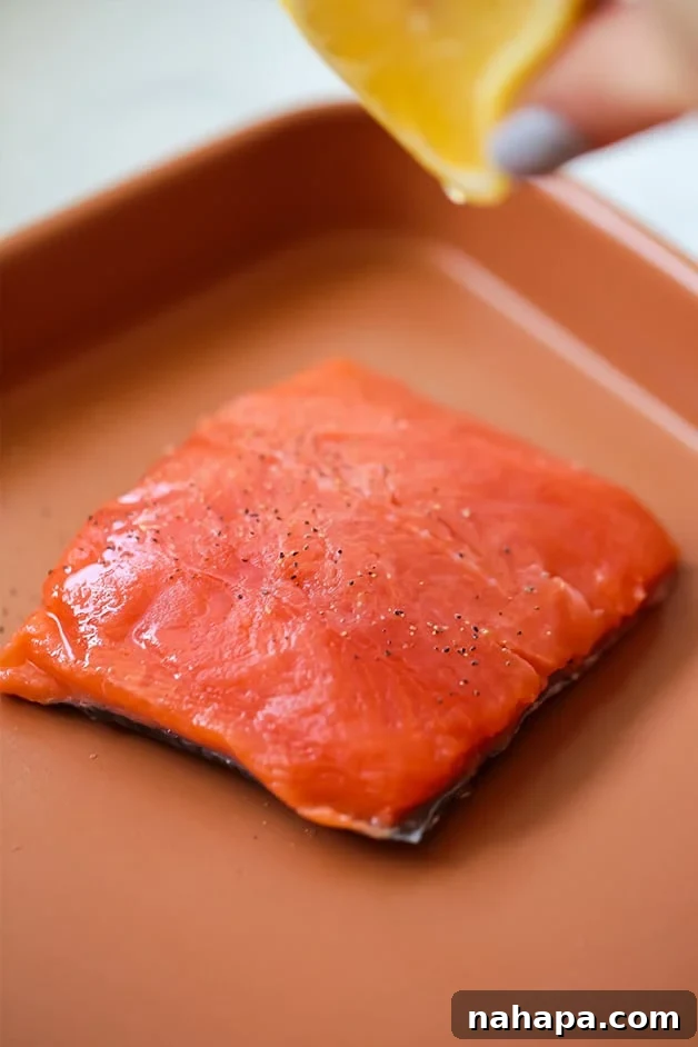 Healthy Paleo AIP Whole30 Salmon Meal Prep Bowls 5 A sheet pan with a raw salmon fillet seasoned and ready for cooking in the oven.
