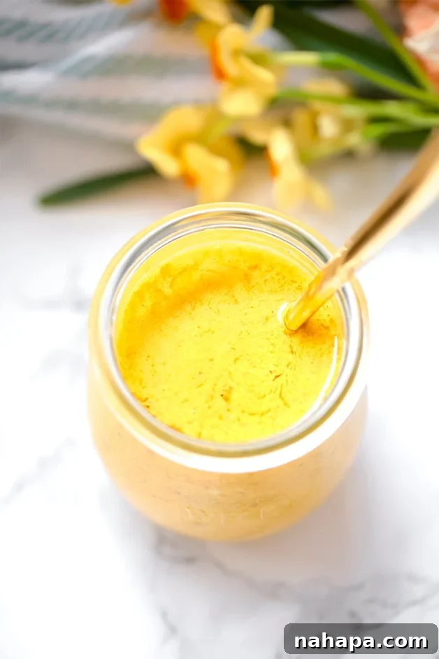 Clean Eating Turmeric Dressing 2 Anti-inflammatory Turmeric Dressing (Paleo, AIP, Whole30) poured over a fresh green salad.