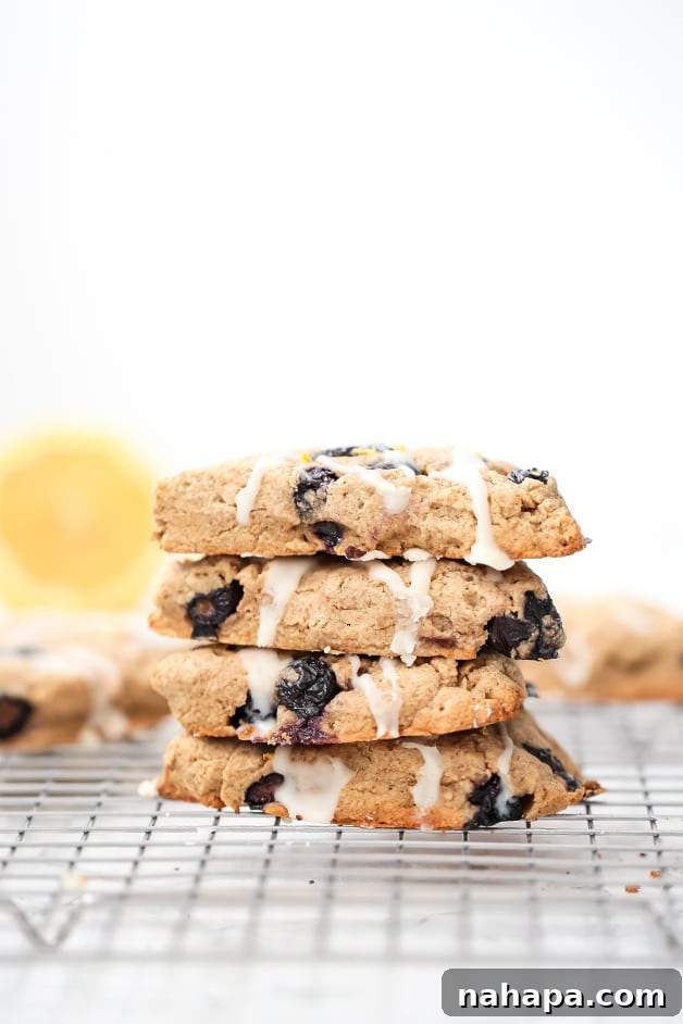 A stack of four lemon blueberry scones stacked on a metal cooling rack.