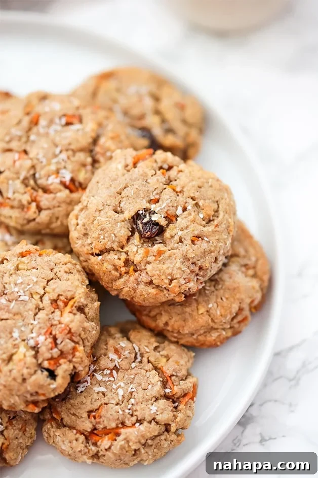 A white plate filled with carrot cake cookies, garnished with shredded coconut.