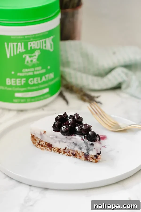 Creamy Dairy-Free Blueberry Lavender Cheesecake AIP Paleo 6 A slice of blueberry lavender cheesecake topped with blueberries on a white plate with a fork next to it.
