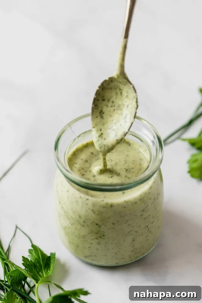 Wholesome Bacon Ranch Sweet Potato Salad 4 A close-up shot of an immersion blender creating a creamy, smooth homemade ranch dressing in a glass jar, highlighting the fresh herbs and rich texture.