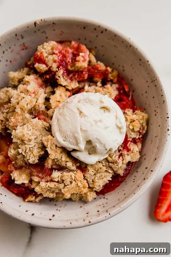 Paleo AIP Vegan Strawberry Rhubarb Crumble 6 A close-up shot of a freshly baked strawberry rhubarb crisp, perfectly golden and bubbly, with a crunchy topping straight out of the oven.