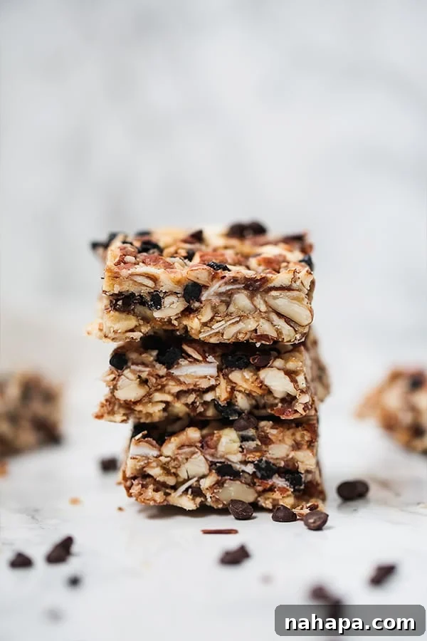 A stack of three homemade granola bars showcasing their wholesome texture