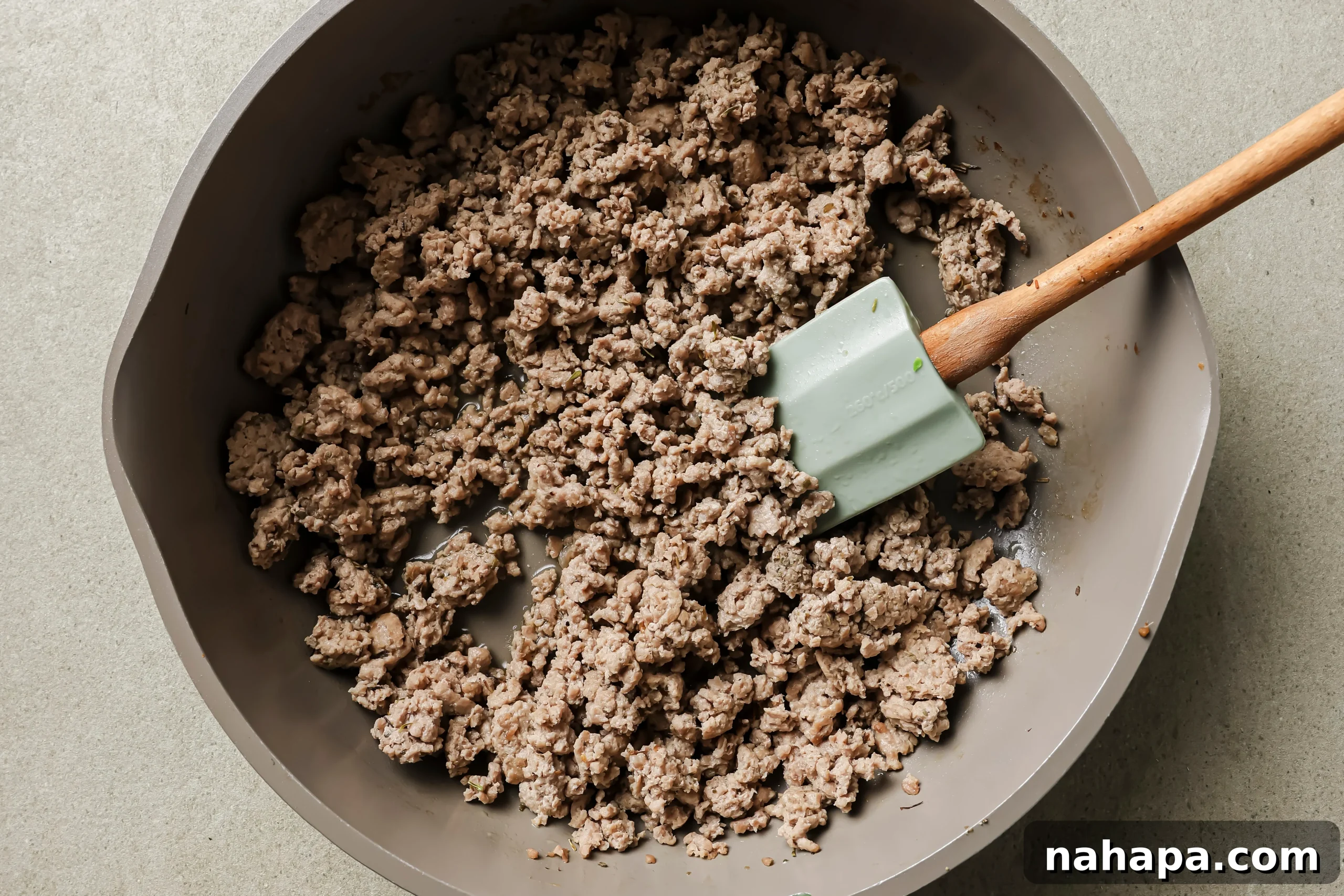 Ground turkey browning in a large cast-iron skillet, lightly seasoned.