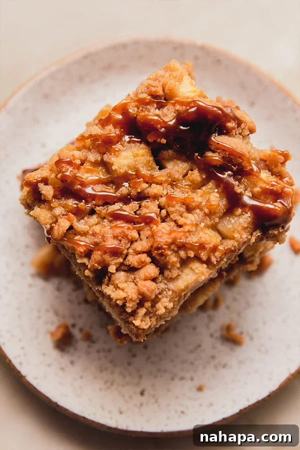 Close-up of a Paleo Apple Pie Bar, showing its crumbly topping and apple filling.